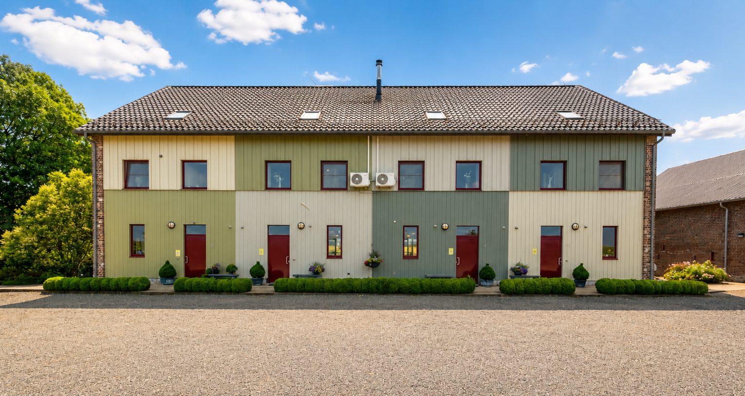De voorgevel met de vier voordeuren: privéwoning, Huis 3, Huis 2 en Huis 1